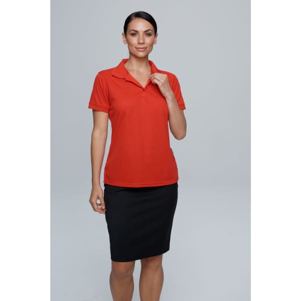 A woman is wearing a red polo shirt paired with a black skirt. The shirt features a logo.