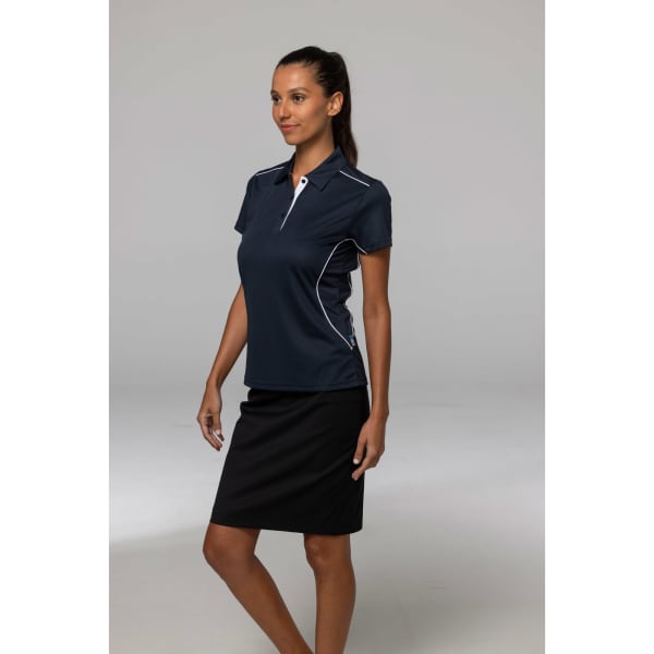 A navy blue polo shirt with white detailing, modelled by a woman standing beside a black skirt.