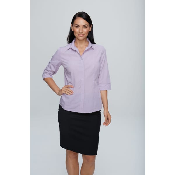 A woman wearing a lilac button-up shirt with 3/4 sleeves and a black skirt, posing against a plain background.