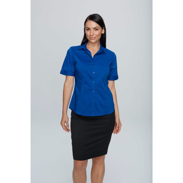 A blue short sleeve button-up shirt displayed on a model, paired with a black skirt. It features a logo.