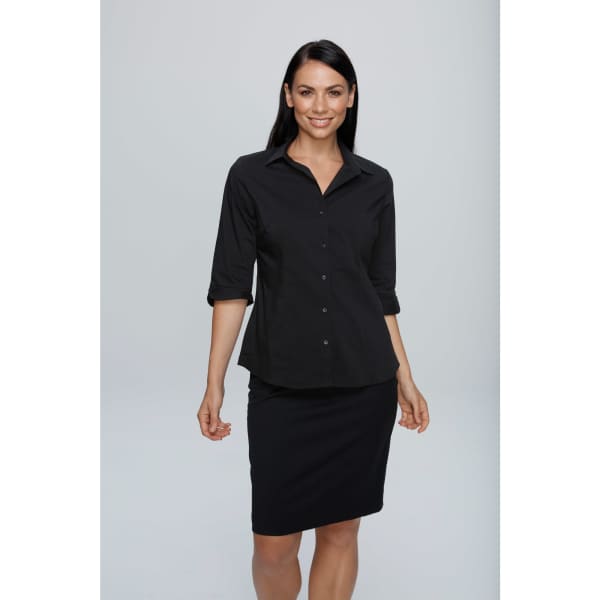 A woman wearing a black 3/4 sleeve button-up shirt paired with a black skirt. The shirt has a collar and buttons.