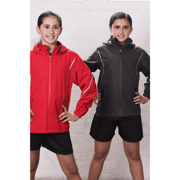 Two children wearing jackets; one in red and the other in black, both standing confidently with hands on hips.