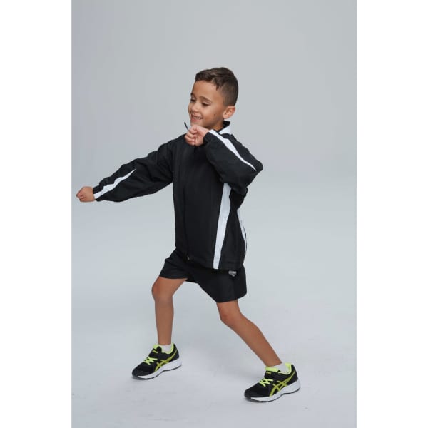 A child in a black track jacket with white stripes, paired with black shorts and green-accented shoes.