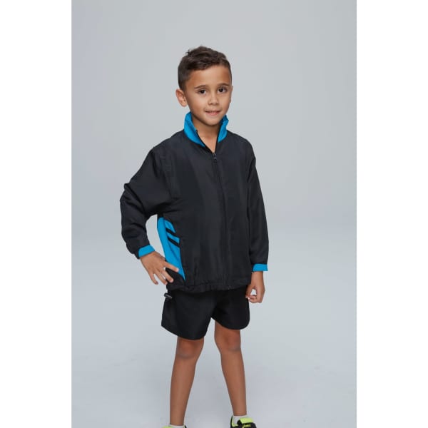 A child wearing a black and blue track top, styled with a zip and contrasting sleeves, paired with black shorts.