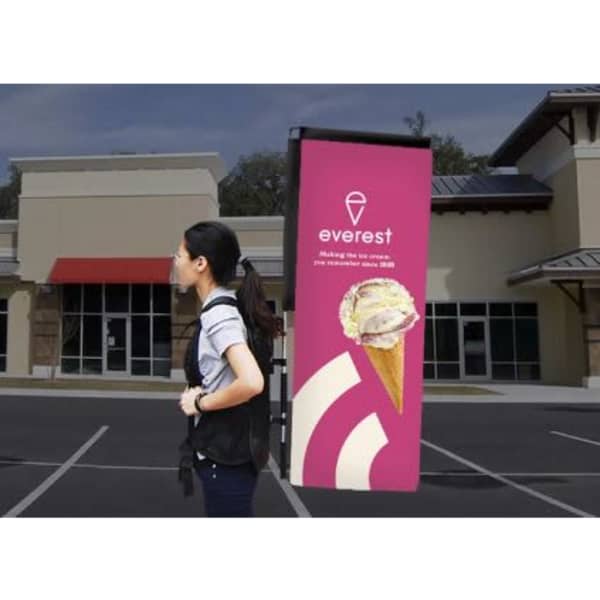 A small double-sided backpack wing banner in vibrant pink, displaying a logo and an ice cream graphic.