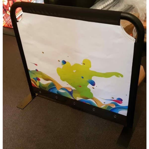 A café barrier featuring a vibrant illustration with green and blue designs, set in a sturdy black frame.