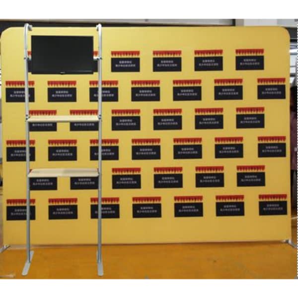 A shelving unit with a yellow background and a screen attached, featuring dark panels without visible text.