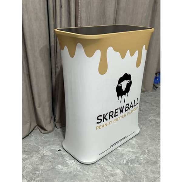 A white and gold hydraulic counter with a wavy design and a logo, set against a grey backdrop.