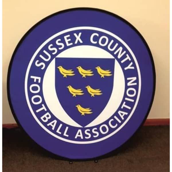 A round pop-up banner with a purple background and a central shield design featuring six yellow birds. It includes a logo.