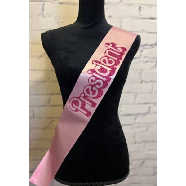 A pink satin sash with the word 