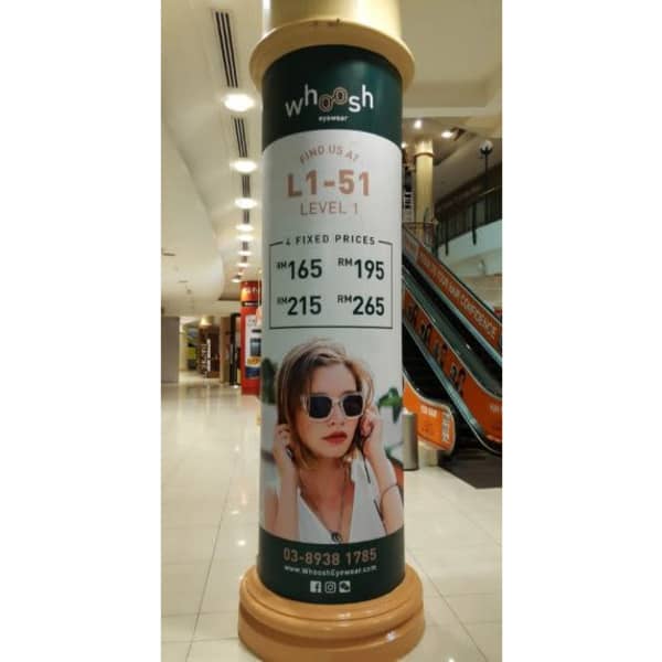 A cylindrical promotional banner featuring a woman wearing sunglasses, with a green and white colour scheme.
