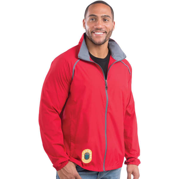 A man models a red packable rain jacket with a grey collar and a logo at the hem.