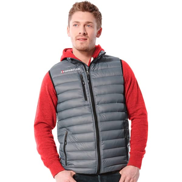 A man models a grey Whistler Light Down Vest over a red hoodie, featuring a logo and zippered pockets.