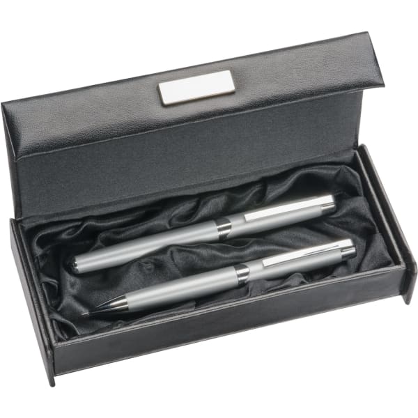 A stylish black leather-look pen box containing two silver pens, set on a soft black lining.