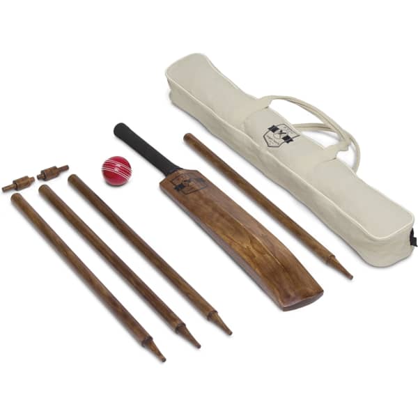 A brown wooden cricket bat, red ball, stumps, and a beige carry bag with a logo.