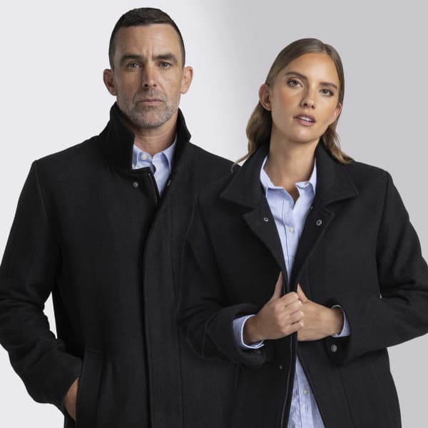 A black wool jacket worn by a man and a woman, featuring a collar and front pockets. The image includes branding.