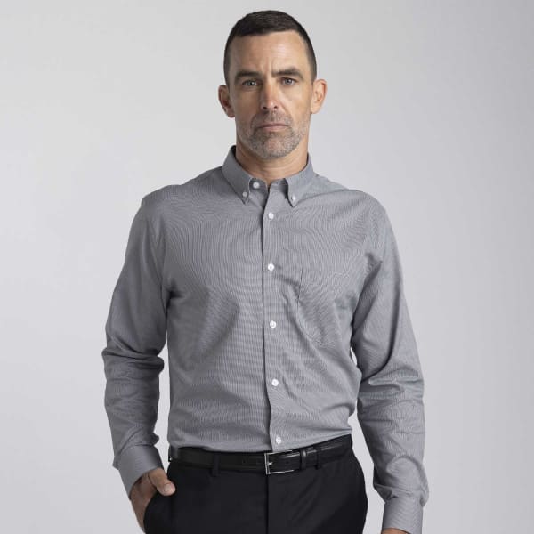 A button-up shirt in grey featuring a collar and long sleeves, with a pocket and a logo visible.
