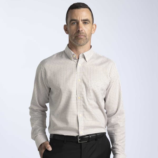 A man wearing a men's button-up shirt featuring a check pattern in muted tones, with a collar and long sleeves.