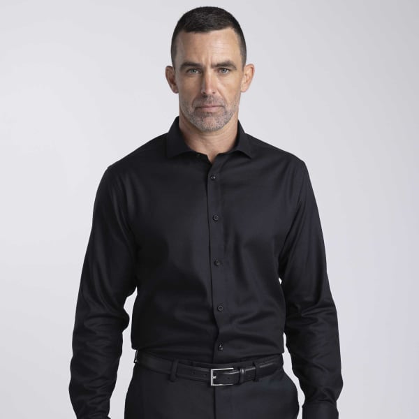 A black button-up shirt for men, featuring a collar, long sleeves, and a branded logo.