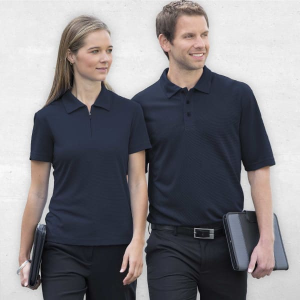 A navy men's polo shirt with a collar and logo, modelled by a man and woman in casual attire.