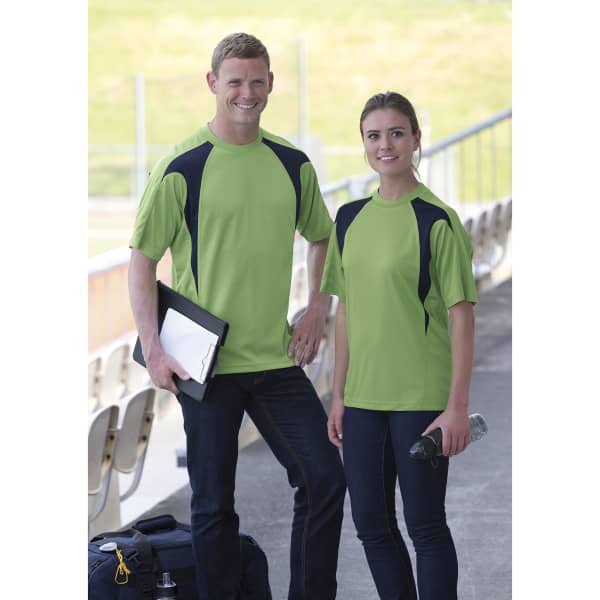 Two individuals wearing bright green Dri Gear Spliced Zenith Impact Tees with navy accents, standing outdoors in casual settings.