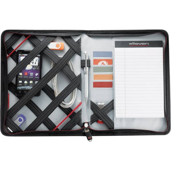 A black and grey multi-pocket organiser featuring a phone, cables, a pen, note pad, and assorted cards.
