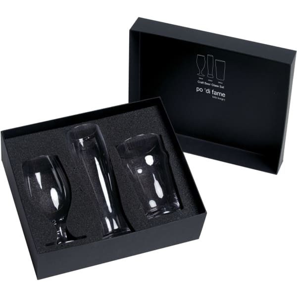 A black gift box contains three clear glass beer glasses in various shapes, nestled in black cushioning.