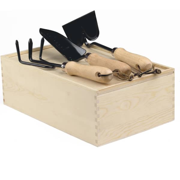 A wooden garden box containing three black gardening tools with wooden handles.