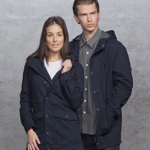 A dark blue twill jacket featuring a hood, front pockets, and a subtle branding element, modeled by two individuals.