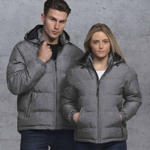 A grey puffer jacket with a hood, modelled by a man and a woman against a textured background. Features a logo.