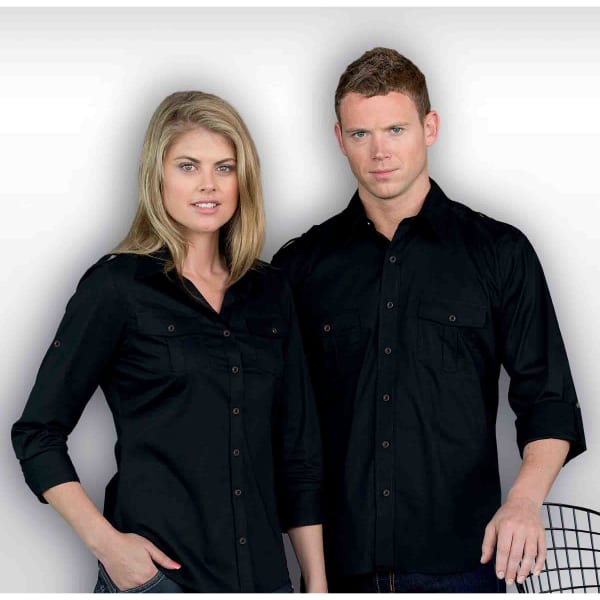 A black button-up shirt for men, featuring two chest pockets and a logo. The model stands alongside a woman in a similar shirt.