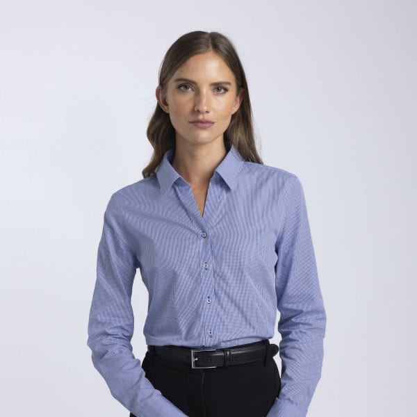 A women's button-up shirt in light blue, featuring a collared neckline and long sleeves, with a brand logo.