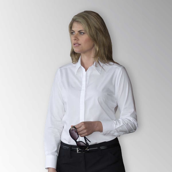 A woman wearing a white button-up shirt, holding sunglasses, with a neutral background. The shirt features a logo.