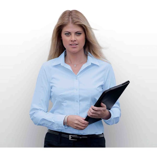 A woman wearing a light blue button-up shirt, holding a black folder, with long blonde hair.