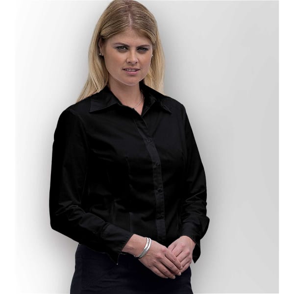 A woman wearing a black button-up shirt with a collar, standing against a neutral background.