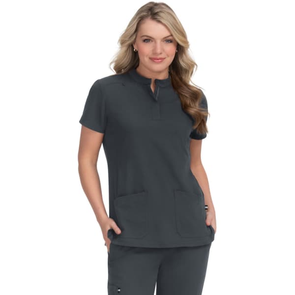 A women's dark grey medical scrubs top featuring a round neckline and two front pockets. It has a logo on the chest.