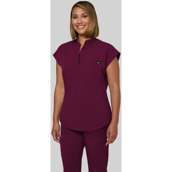 A purple scrub top with a collar and cap sleeves, featuring a logo on the chest.