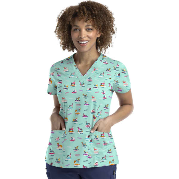 A printed curved V-neck top in mint green featuring a variety of colourful patterns and two front pockets.