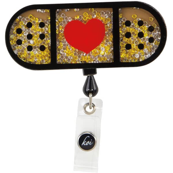 A black shaker badge with a heart design and colourful glitter elements, featuring a logo on the bottom.