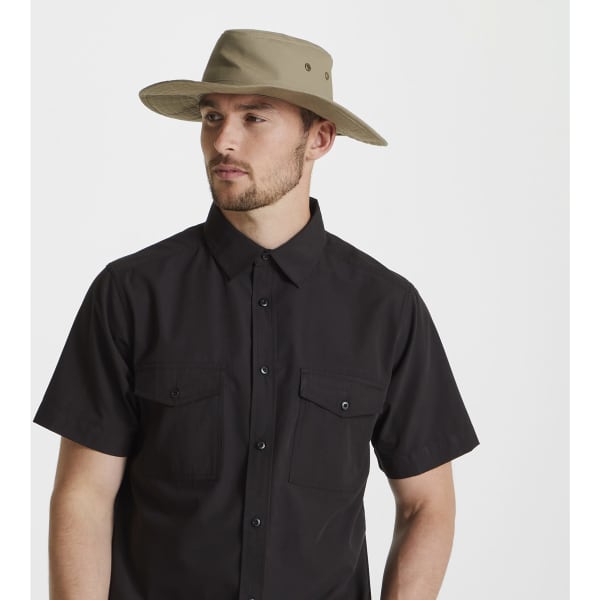 A man wearing a tan Kiwi ranger hat with a black shirt featuring two chest pockets.