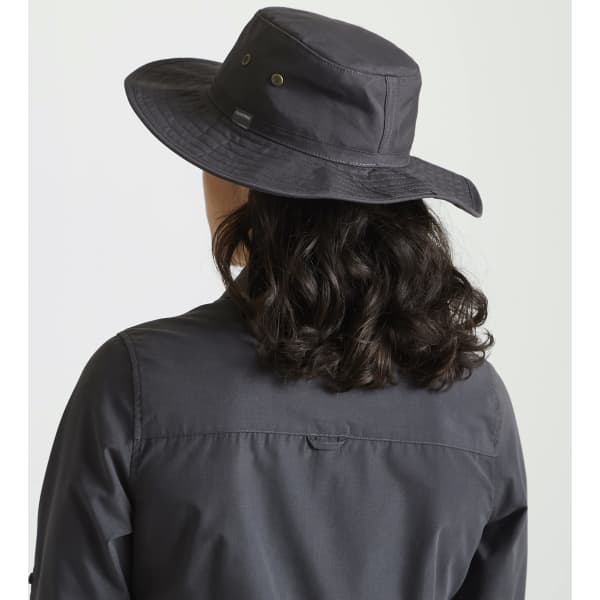 A black Kiwi ranger hat with a wide brim, featuring a logo, worn by a person with curly hair.