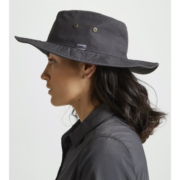 A black ranger hat with a wide brim, featuring metal eyelets, worn by a woman in profile.