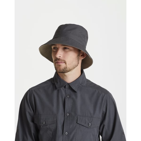 A person wearing a dark grey Kiwi reversible sun hat, featuring a wide brim and a stylish design.