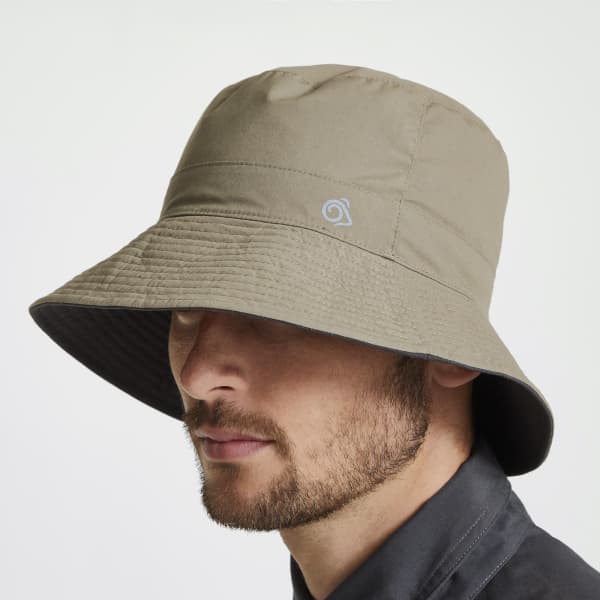 A bucket hat in khaki with a grey trim and a logo, featuring a wide brim for sun protection.