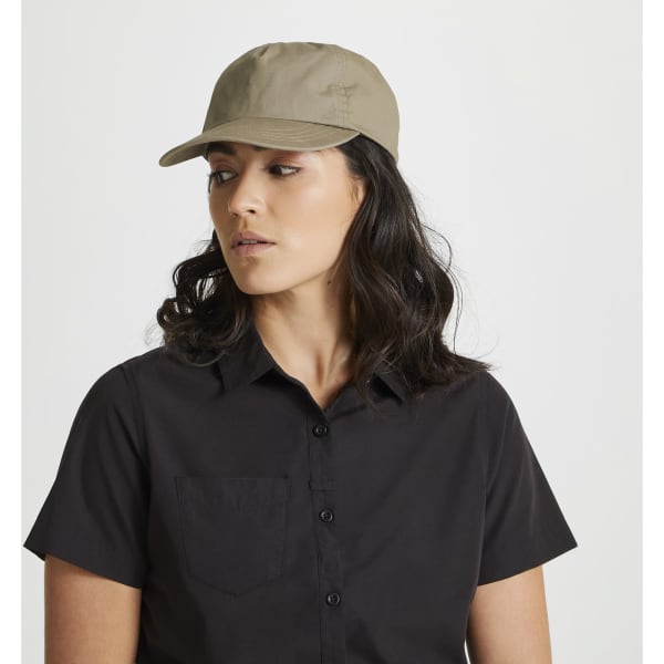 A beige trucker cap worn by a person with dark hair, featuring a simple design and a logo.