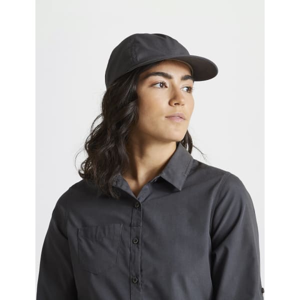 A dark grey trucker cap is worn by a person with long, wavy hair, paired with a matching button-up shirt.