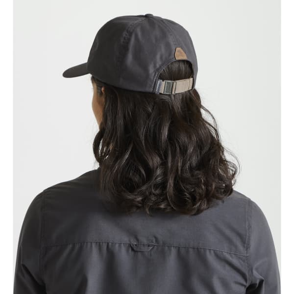A dark grey trucker cap with an adjustable strap, viewed from the back, styled with loose, wavy hair.