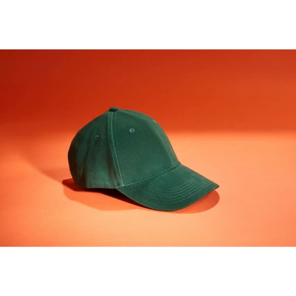 A green six-panel cap with a curved peak, set against an orange background. The cap features a logo.