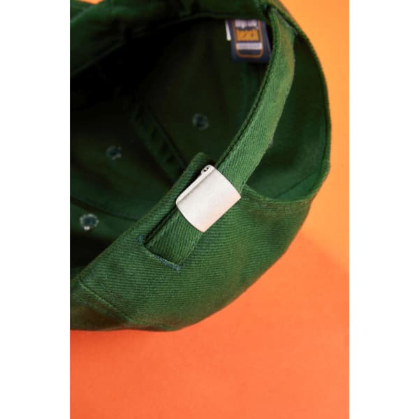A green low-profile cap featuring an adjustable strap and a branding logo inside.