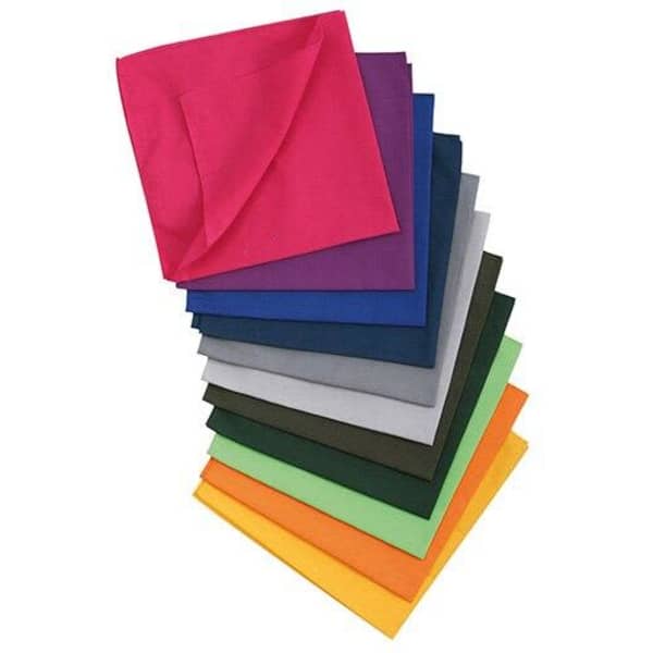 A stack of bandanas in various colours, including pink, purple, blue, grey, green, and orange. Each has a solid design and branding.